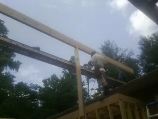 Carpenter setting a ridge beam over a new addition frame — Ice Dam Removal by Roofing Brothers in Mountain Lakes