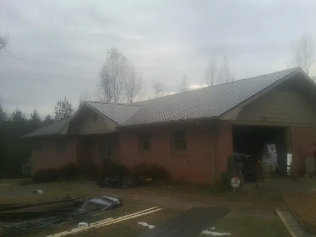 Gray metal roof on a stucco house with an attached garage in Mountain Lakes