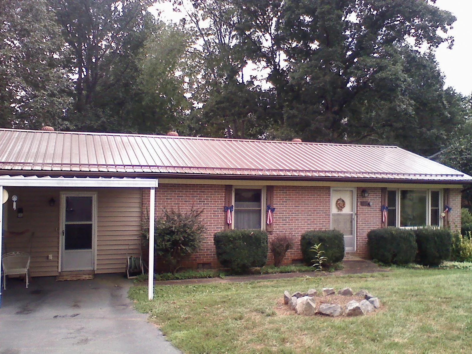 Bronze metal roof and carport on a brick ranch home — Roof Repair work by our crew in Mountain Lakes